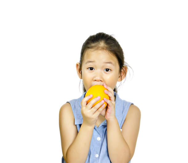 istock asian little girl holding fresh orange 1126434548