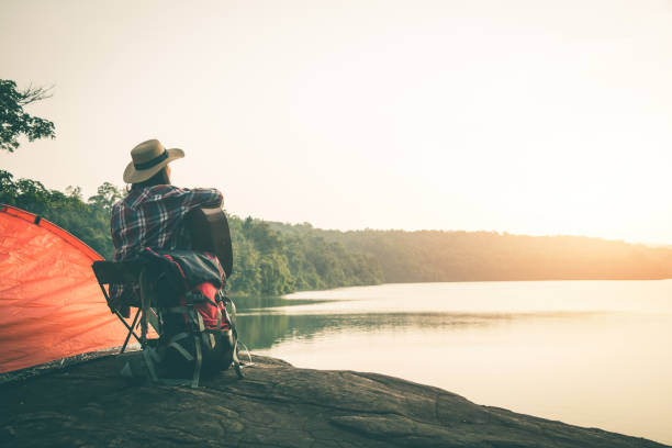 istock Rear View Of Woman Playing Guitar While Sitting By Lake During Sunset 1126436521