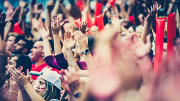 istock Crowd cheering for their team with arms raised 1126437600