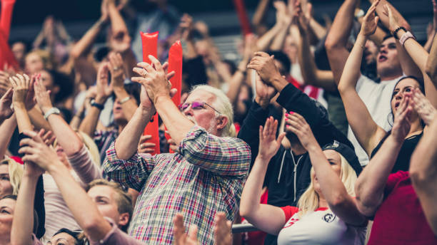 istock Crowd cheering for their team with arms raised 1126437605