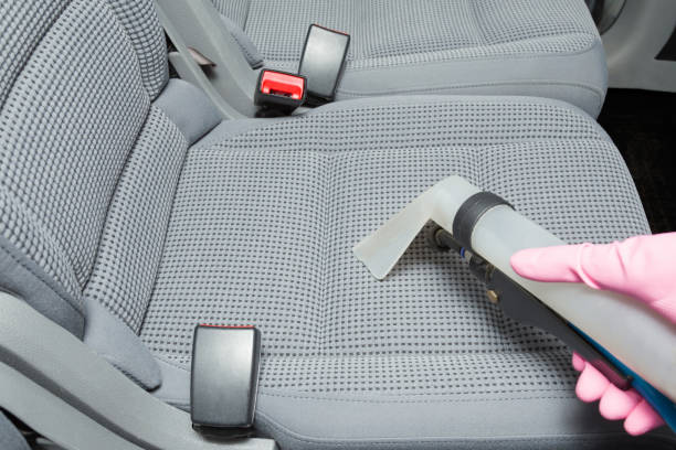 istock Employee hand in rubber protective glove vacuuming passenger gray textile back seat with professionally extraction method. Care about auto interior. Commercial cleaning company. Close up. 1126437689