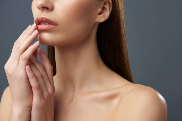 istock Young woman with beautiful full lips posing on blue-gray background 1126439804