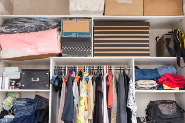 Open wardrobe with things and boxes in the bedroom