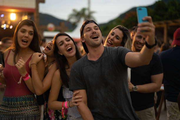 amigos tomando un selfie en fiesta en la playa - mobile phone group of people photographing teenager fotografías e imágenes de stock