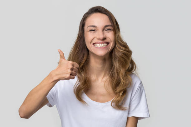 istock Young satisfied woman showing thumbs up looking at camera 1126440347