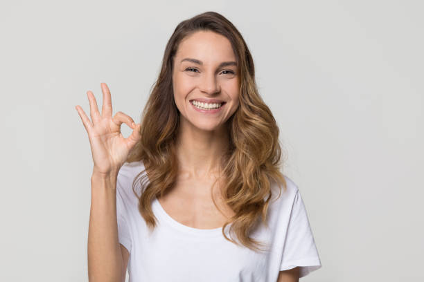 istock Happy woman gesturing ok smiling looking at camera on background 1126440355