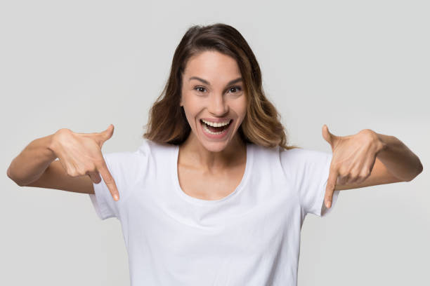 istock Happy girl pointing fingers below isolated on blank background 1126440356