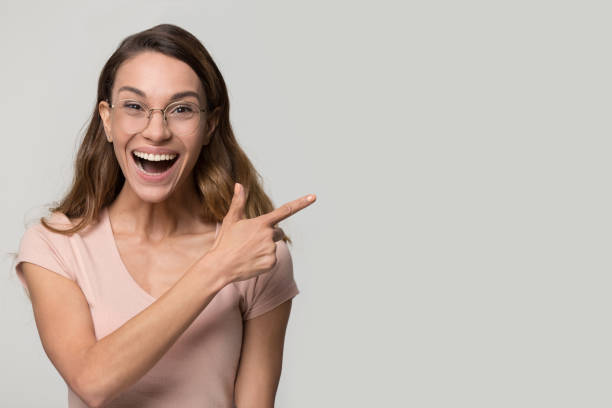 istock Excited happy lady wearing glasses pointing finger at copy space 1126440389