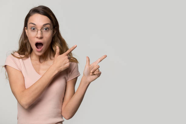 istock Surprised girl looking at camera point fingers at copy space 1126440396