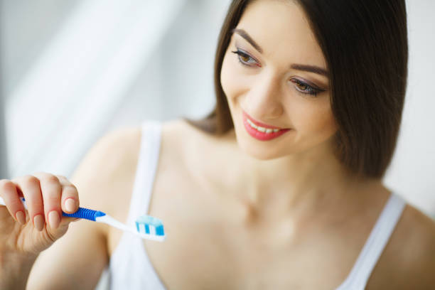 istock Beautiful Smiling Woman Brushing Healthy White Teeth With Brush. High Resolution Image 1126440435