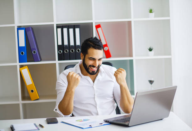 istock Handsome businessman sitting on his desk in the office 1126442322