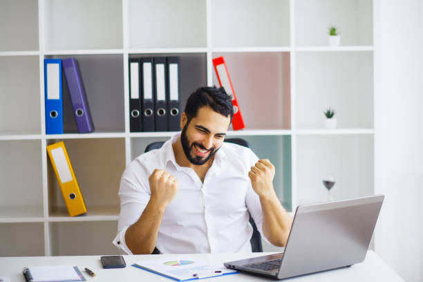 istock Handsome businessman sitting on his desk in the office 1126442519