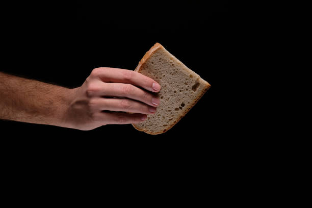 istock Man's hand holding slice of bread. 1126443630