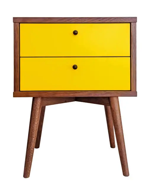 Photo of Yellow wood bedside table. Modern designer nightstand isolated on white background front view. cabinet with two drawers