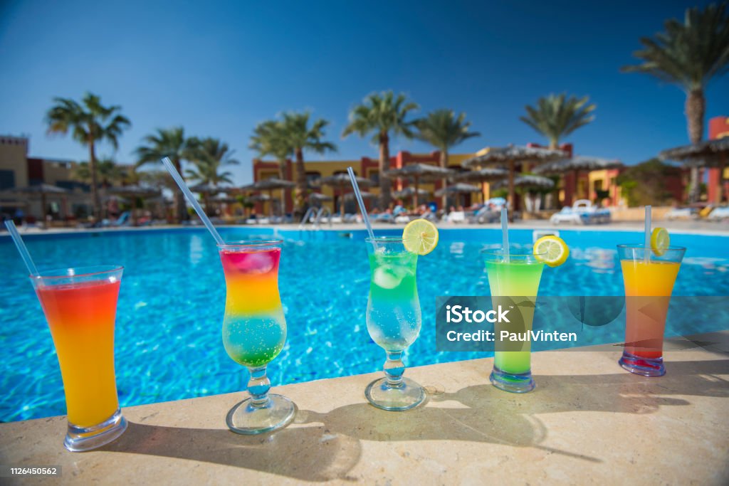 Five cocktail drinks by a tropical swimming pool Five cocktail drinks by a tropical hotel resort swimming pool in summer Poolside Stock Photo
