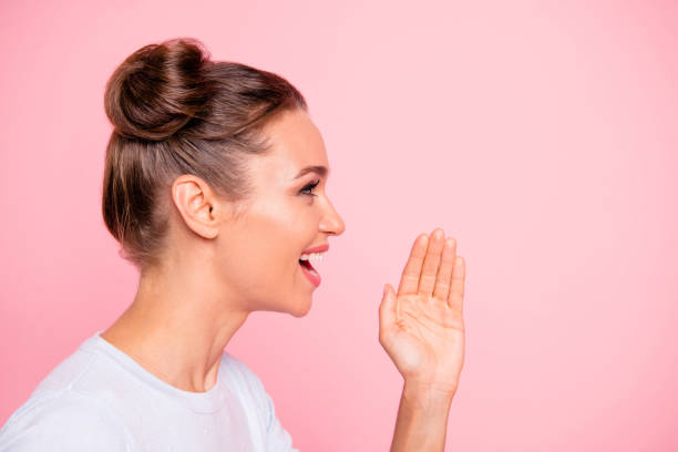 Profile side view portrait of her she nice winsome attractive lovely sweet cheerful cheery girl lady saying speech story teller isolated over pastel pink background Profile side view portrait of her she nice winsome attractive lovely sweet cheerful cheery girl lady saying speech story teller isolated over pastel pink background topknot stock pictures, royalty-free photos & images