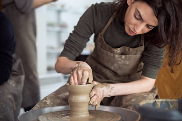 Ceramic workshop Young woman artist making clay bowl on pottery wheel sculptor stock pictures, royalty-free photos & images