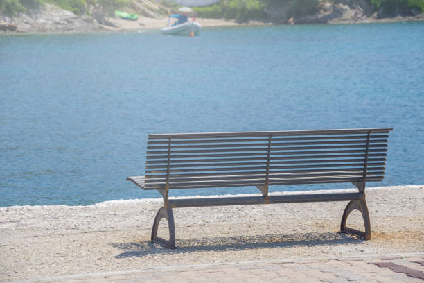 istock Iron bench near blue sea water for rest after a walk 1126454255