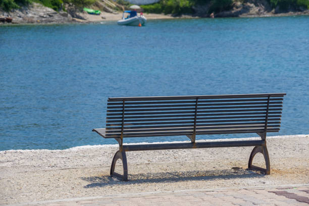 istock Iron bench near blue sea water for rest after a walk 1126454304