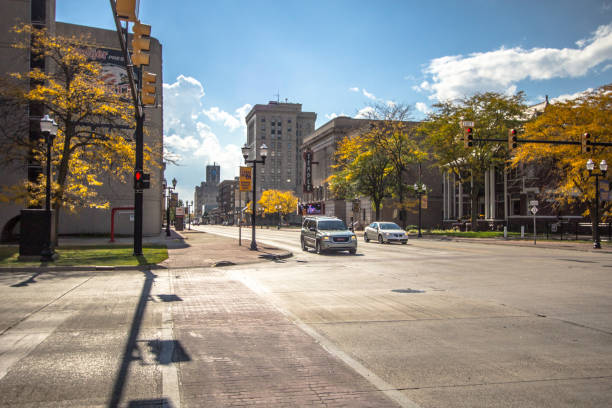 Streets Of Downtown Saginaw Michigan Saginaw, Michigan, USA - October 9, 2018: Intersection on the streets of downtown Saginaw Michigan with autumn foliage in the background. walking point of view stock pictures, royalty-free photos & images