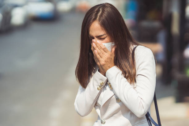 donna asiatica sta andando a lavorare.indossa maschera n95.prevenire pm2.5 polvere e smog.lei sta tossendo - maschera da subacqueo foto e immagini stock