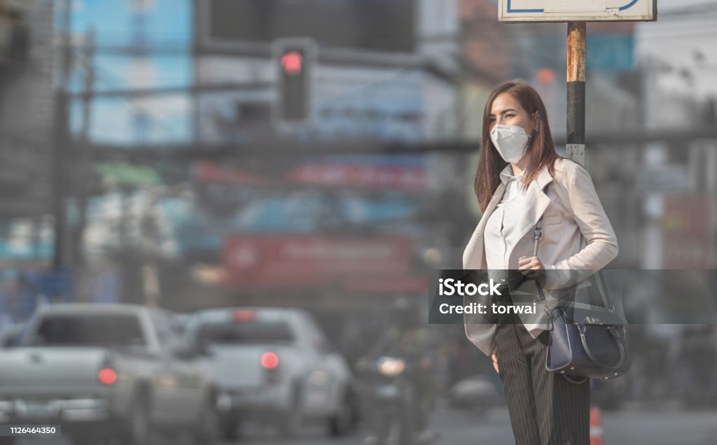 Asian woman are going to work.she wears N95 mask.Prevent PM2.5 dust Asian woman are going to work.she wears N95 mask.Prevent PM2.5 dust and smog Pollution Stock Photo