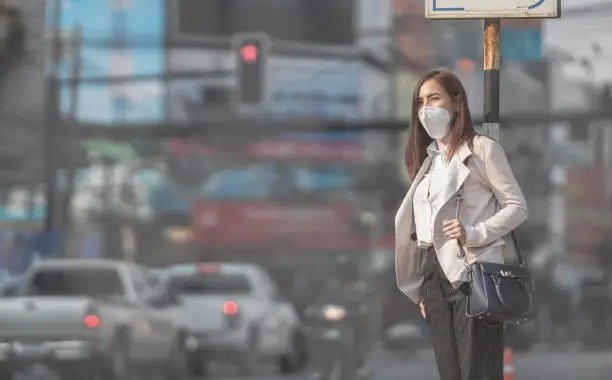 Photo of Asian woman are going to work.she wears N95 mask.Prevent PM2.5 dust