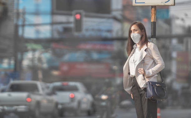 mulher asiática vão work.she usa n95 máscara. impedir que a poeira de pm2,5 - poluição - fotografias e filmes do acervo