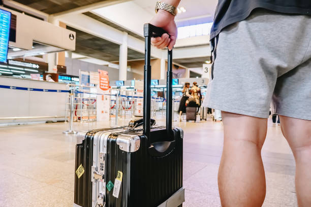 バンコク タイ - 2018年 11 月 22:man 空港で荷物を持って立っています。男がラウンジをご出発前に搭乗口で待っている間飛行機を見て見て。 - concepts airport ideas watching ストックフォトと画像