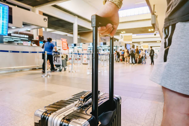 バンコク タイ - 2018年 11 月 22:man 空港で荷物を持って立っています。男がラウンジをご出発前に搭乗口で待っている間飛行機を見て見て。 - concepts airport ideas watching ストックフォトと画像