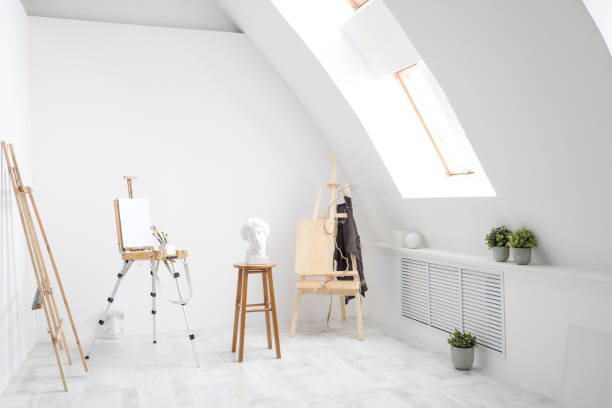 istock White and bright studio with a window. Workspace of the artist. Easel, canvases and plaster figures for learning to draw. 1126468806