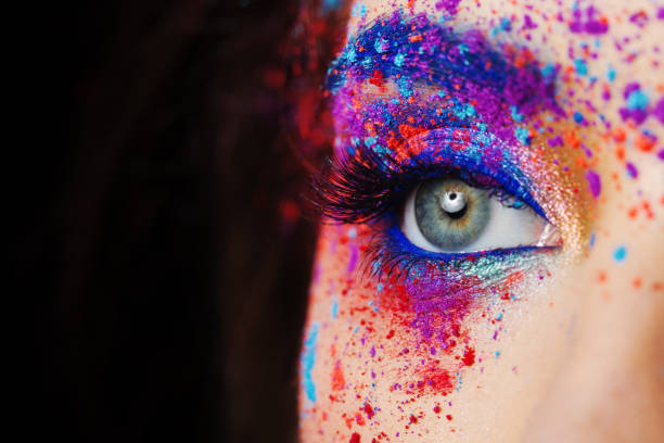 explosion of color, multi-colored shadows scattered on the eyelids. Colored Smokey eyes and blue eyebrows. Fashion portrait close up