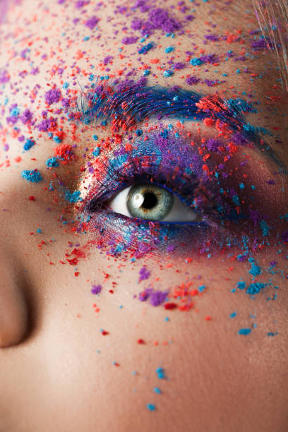 istock explosion of color, multi-colored shadows scattered on the eyelids. Colored Smokey eyes and blue eyebrows. 1126469015