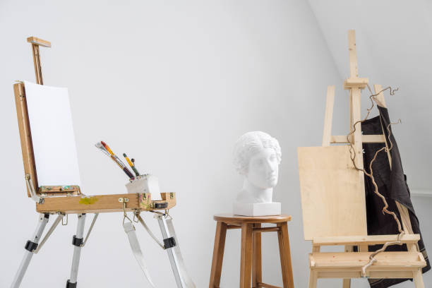 istock White and bright studio with a window. Workspace of the artist. Easel, canvases and plaster figures for learning to draw. 1126471375