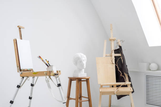 istock White and bright studio with a window. Workspace of the artist. Easel, canvases and plaster figures for learning to draw. 1126471456