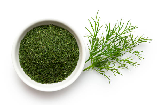 istock Dried chopped dill in white ceramic bowl next to fresh dill leaves isolated on white from above. 1126475133