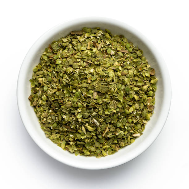 istock Dried chopped oregano in white ceramic bowl isolated on white from above. 1126475938