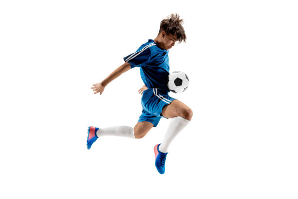 ragazzo con palla da calcio che fa calcio volante - little boys people indoors soccer foto e immagini stock