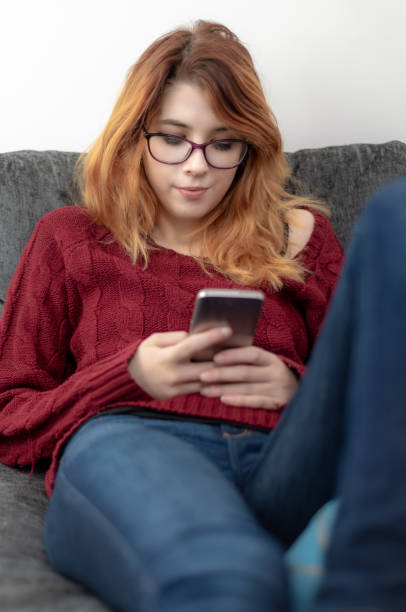 istock Young woman at home, uses a smartphone to text/use internet 1126476429