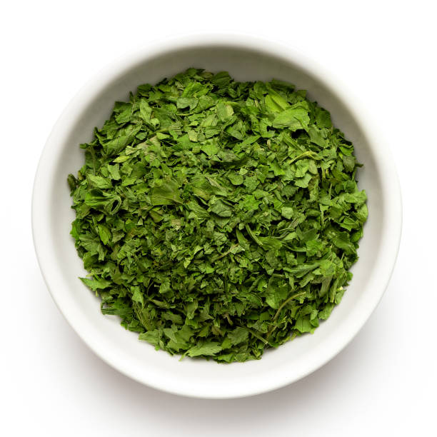 istock Dried chopped parsley in white ceramic bowl isolated on white from above. 1126476847