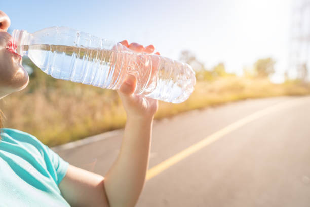 istock Midsection Of Woman Drinking Water On Road During Sunny Day 1126477342