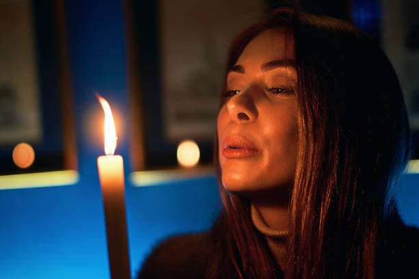 istock Young beautiful woman blowing out a candle 1126477987