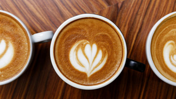 istock Cups of cappuccino coffee on a wooden table 1126480494