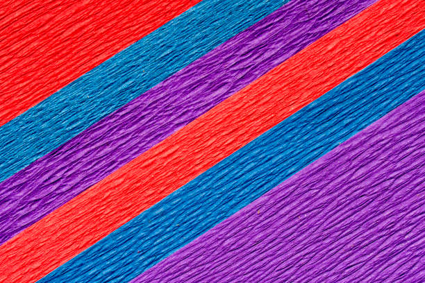 An abstract textured background of brightly colored red blue and purple crepe paper