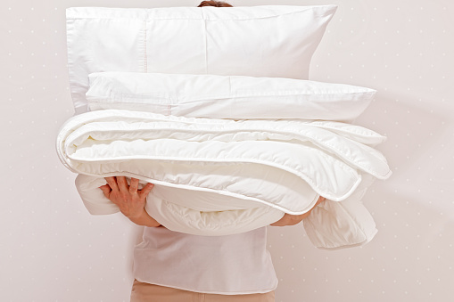 Mujer sosteniendo un montón de ropa de cama para dormir. Hogar photo