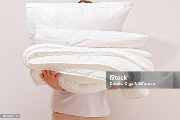 Woman Holding A Pile Of Bedding For Sleeping Household Stock Photo - Download Image Now