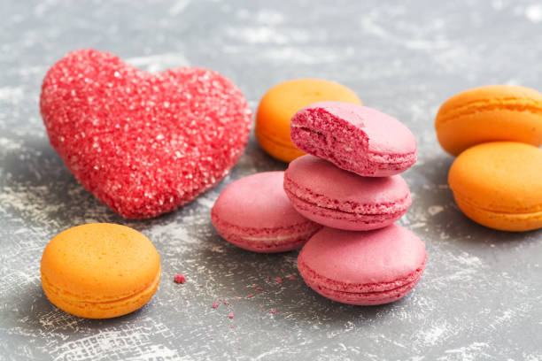 istock Yellow and pink macaroons with red sugar hearts. Selective focus. 1126482128