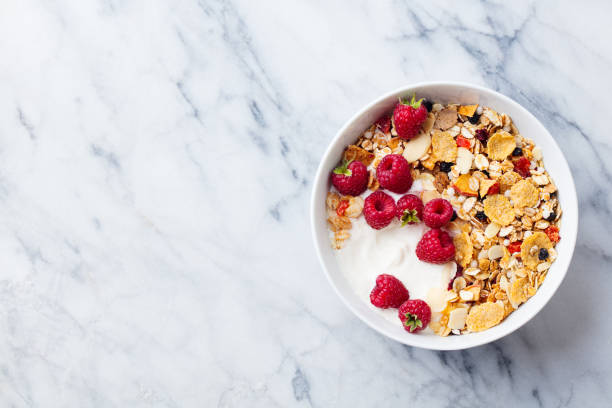 istock Healthy breakfast. Granola, muesli with yogurt and berries. Marble background. Top view. Copy space. 1126485151