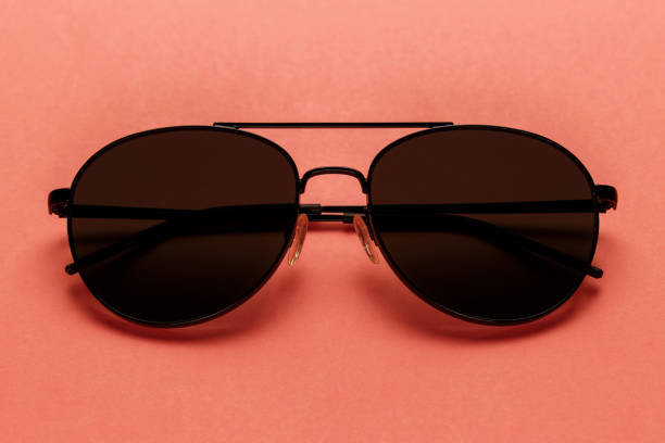 istock Close-up sunglasses on coral background. Top view. Flat lay. Copy space. New minimal creative concept. Summer is coming concept. Living Coral color of the Year 2019 1126485188
