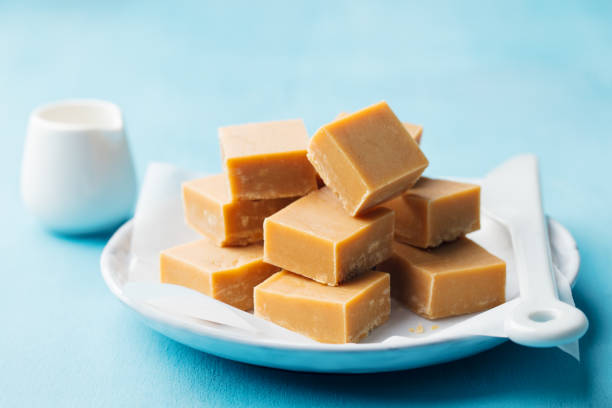 istock Caramel fudge candies on a plate. Blue background. Close up. 1126490388